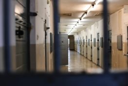 View of prison corridor from behind bars.