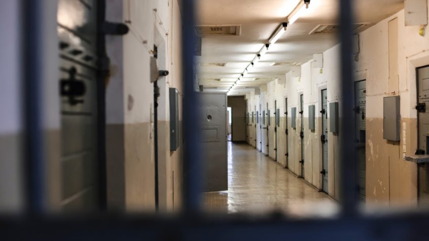 View of prison corridor from behind bars.