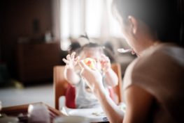 Woman feeding toddler.