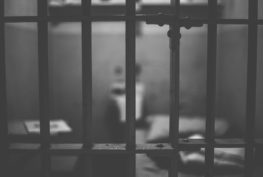 View looking into jail cell from outside the cell's bars.