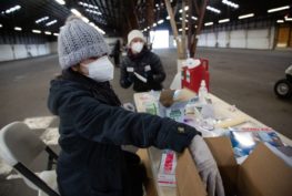 Jennifer Park, left, and Kristen Morin prepare to deliver vaccines to people at a mass vaccination site in Ridgefield, Washington, on Jan. 26, 2021. Community activists are calling on Washington to more equitably dole out doses of the vaccine to people of color. Troy Brynelson / OPB