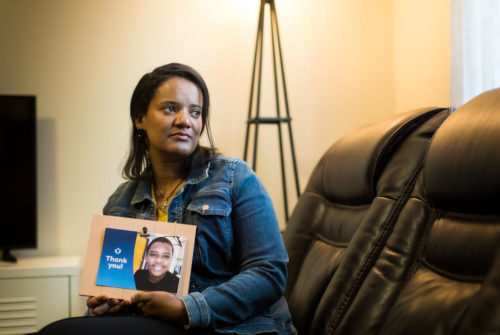 Meseret Haile with a photo of her son Leoul in Bellevue. Leoul, who has special needs, is in a facility in Kansas because Washington state doesn’t have adequate facilities. (Dan DeLong/InvestigateWest)