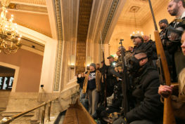 A I-594 protest participants holding long guns in the House gallery