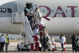 Afghan evacuees disembark the plane and board a bus after landing at Skopje International Airport, North Macedonia, on Sept. 15, 2021. (AP Photo/Boris Grdanoski, file)
