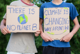 Photo of children holding signs encouraging action on climate change